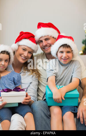 Noël en famille hat holding présente sur canapé Banque D'Images