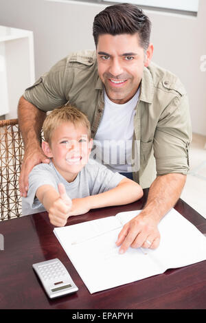 Heureux père fils aidant à faire ses devoirs de mathématiques à table Banque D'Images