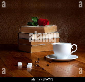 Tasse de café frais sur la table en bois et pile de livres à lire à la rose Banque D'Images