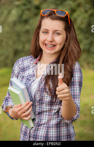 Étudiant avec accolades showing thumb jusqu'à l'extérieur Banque D'Images