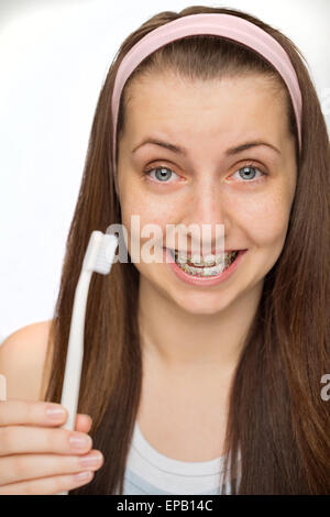 Girl wearing accolades montrant une brosse à dents Banque D'Images