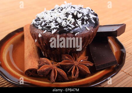 Des délicieux muffins au chocolat frais cuit avec noix de coco desséchée, morceaux de chocolat et l'anis étoilé se trouvant sur la plaque Banque D'Images