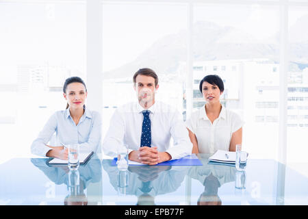 Smartly dressed young executives sitting at desk Banque D'Images