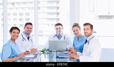 Smiling medical team autour de desk in office Banque D'Images