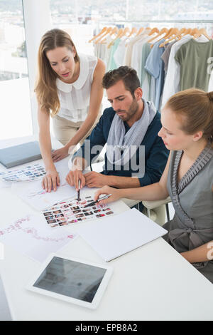 Trois fashion designers discussing designs Banque D'Images