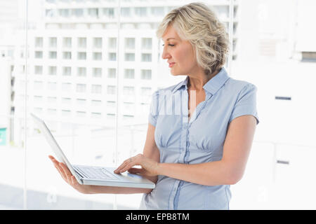 Businesswoman using laptop in office Banque D'Images