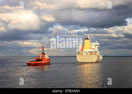 Navire-citerne d'escorter des remorqueurs de quitter le port. Banque D'Images