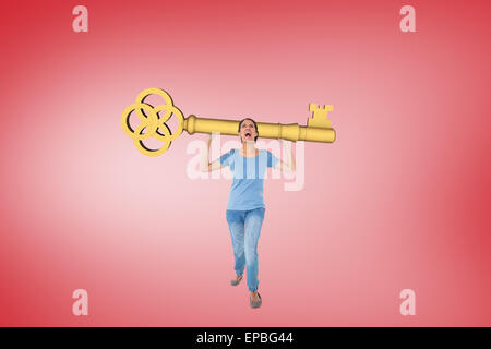 Image composite de l'ennuyé brunette carrying large key Banque D'Images