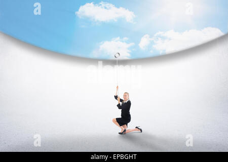 Image composite de businesswoman pulling down blue sky Banque D'Images