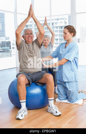 Female therapist aider senior couple avec des exercices Banque D'Images