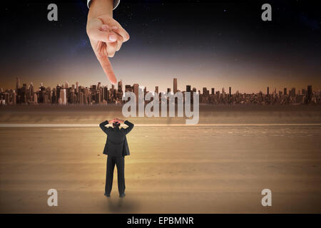 Main géante pointing at businessman standing retour à l'appareil photo avec les mains sur la tête Banque D'Images