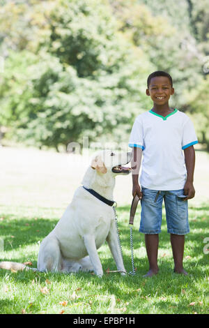 Petit garçon debout avec son animal labrador dans le parc Banque D'Images