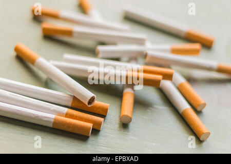 Arrangement de la cigarette sur la surface du bois vert grungy, contexte de l'industrie du tabac Banque D'Images