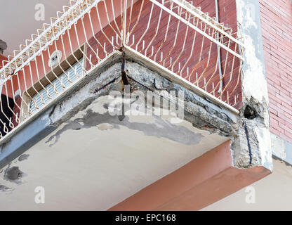 Un balcon avec béton fissuré et un fer rouillé nécessitant une rénovation. Banque D'Images