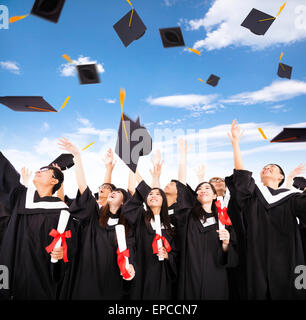 Les élèves heureux de lancer l'obtention du diplôme les bouchons dans l'air Banque D'Images