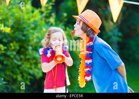 Deux enfants néerlandais, adolescents et petite fille, fans et supporters de l'équipe néerlandaise de football, la célébration de la victoire du championnat Banque D'Images