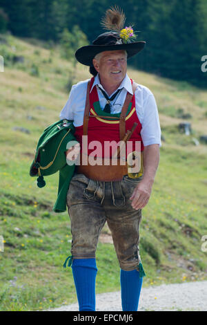 Schützenschwegler Telfer, un musicien du Tyrol en costume traditionnel rouge et vert, ceinture de cuir et un pantalon en cuir noir et hat walking Banque D'Images