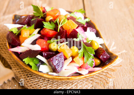 Salade de betteraves. Salade de betteraves rouges traditionnel russe (la vinaigrette :) de betterave, pomme de terre, carotte, petits pois, le chou et le persil sur rustic Banque D'Images