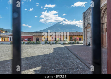 Avis de boutiques sur la rue en face de l'immeuble le Compañí-a de Jesús à Antigua au Guatemala qui abrite la bibliothèque et centre culturel. Volcan Aqua est dans la distance. Banque D'Images