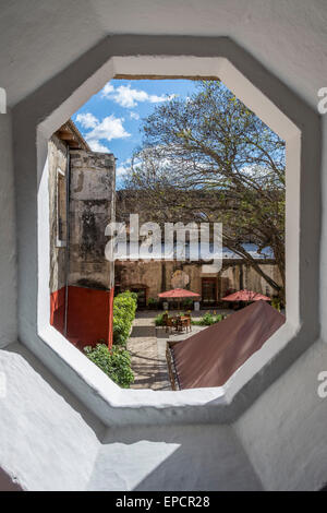 Encadrée par une fenêtre de l'Compañí-a de Jesús Building à Antigua au Guatemala qui abrite la bibliothèque et centre culturel. Banque D'Images