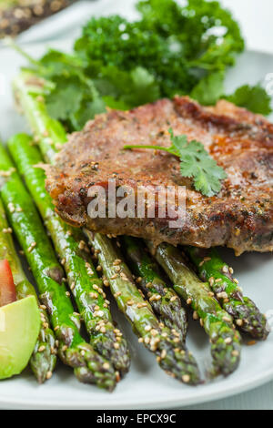 L'asperge verte émaillée de graines de sésame et côtelette de porc grillée Banque D'Images