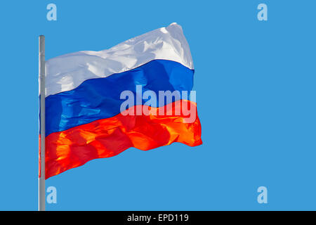 Brandissant le drapeau de la Russie est en face de ciel bleu Banque D'Images