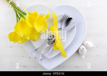 Thème jaune et blanc table mariage place avec plaques en forme de coeur blanc sur la table en bois de style shabby chic. Banque D'Images