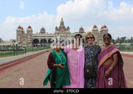 L'intérieur du palais du Maharaja : un occidental pose avec les femmes indiennes en face du palais Banque D'Images