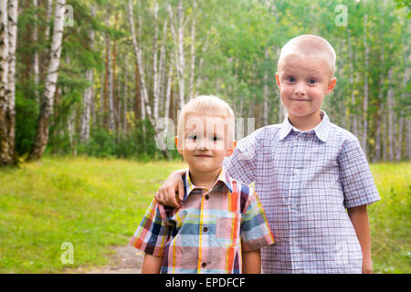 Deux beaux enfants blonds smiling happy joyeux (petits garçons, frères) à l'extérieur et s'amuser dans le parc d'été. Camaraderie et fr Banque D'Images