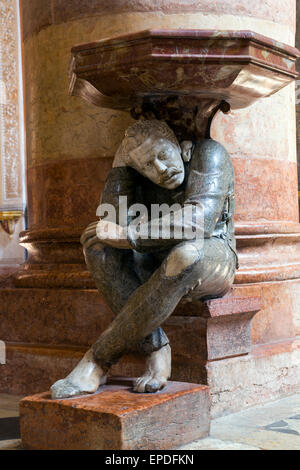 La figure accroupie sous le bénitier dans l'église de Santa Anastasia a été sculpté par Paolo Orefice. Il est connu comme "Pasquino" Banque D'Images