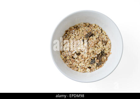 Mélange de céréales avec les pruneaux et les raisins secs dans un plat blanc Banque D'Images