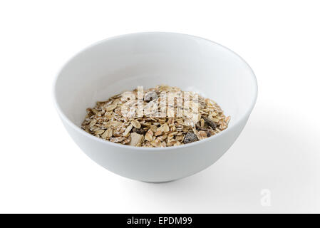 Mélange de céréales avec les pruneaux et les raisins secs dans un plat blanc Banque D'Images