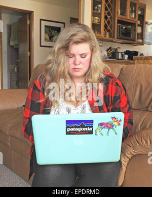 Une adolescente sur son ordinateur portable. Banque D'Images