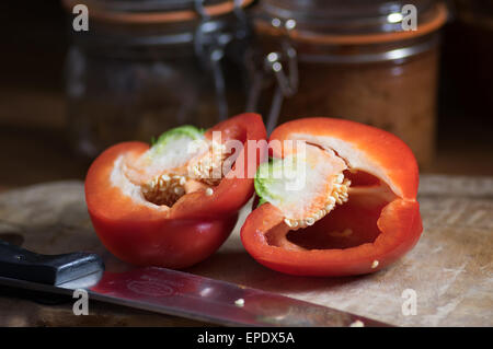 Un poivron rouge, coupé en deux, sur une planche, prêt à cuisiner. Banque D'Images