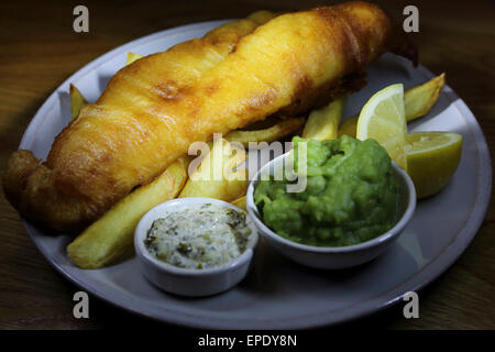 Poisson-frites servi avec des petits pois et sauce tartare au St Mary's Inn près de Stannington dans le Northumberland. Banque D'Images