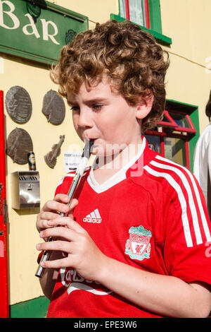 Penny Whistle,lecture,,Liverpool Football Club, portant chemise enfant, garçon, à l'extérieur,pub maintient en vie les traditions musicales locales.at, Feakle Festival, Irlande, Banque D'Images