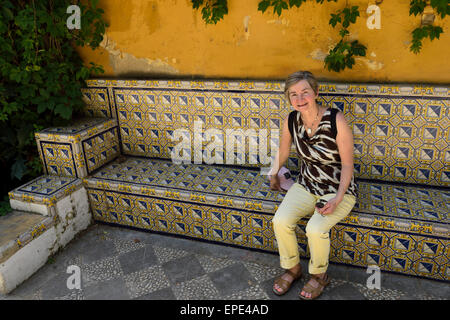 Fatigué woman sitting on bench carrelée à Calle Antonio el Balarin Séville Espagne Banque D'Images