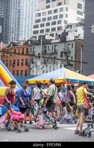 New York, USA. 17 mai, 2015 jeunes & adultes multiethnique. manger des aliments de rue et jouer à l'assemblée annuelle de la 9e Avenue International Food Festival dans le quartier Hell's Kitchen sur fond de Midtown Manhattan. Inauguré en 1973, le festival s'étend à partir de la 57e à la 42e rue, le long de 9e Avenue à New York's Hells Kitchen quartier. Credit : Dorothy Alexander/Alamy Live News Banque D'Images