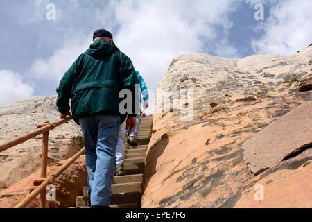 Bob tirant de l'arrière tout en montant les escaliers de grès de faire face à de nouveaux Mexique - USA. Banque D'Images