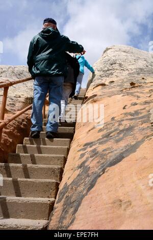 Les personnes âgées en prenant un escalier raide montée vers le haut de la falaise de grès, El Morro National Monument Nouveau Mexique - USA Banque D'Images