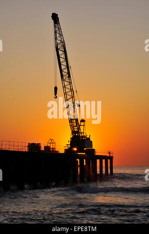 Silhouette d'heavy duty crane sur une jetée à la construction de site au début du matin Banque D'Images
