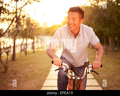 Man riding bike in park Banque D'Images