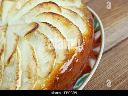 Tarte Normande - variante de la tarte aux pommes faite en Normandie rempli de pommes, amandes effilées et sucre garnie de crème anglaise oeuf crémeux Banque D'Images