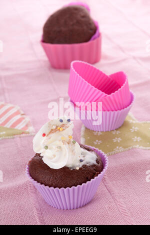 Cuisson de pain délicieux encore en vie en rose pourpre. Formes de cuisson muffins muffins et finis. Dessert sucré culinaire de manger. Banque D'Images