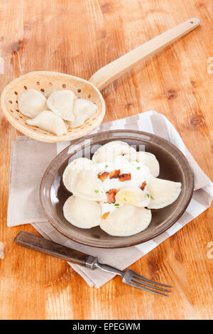 Bryndzove pirohy sur fond de bois avec du scoop et de la fourchette. Vintage style rustique, traditionnel slovaque de manger. Banque D'Images