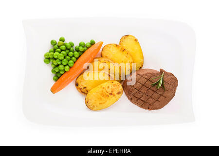 Mignon de boeuf avec des pommes de terre et les pois sur plaque blanche isolé sur fond blanc, vue du dessus. Banque D'Images