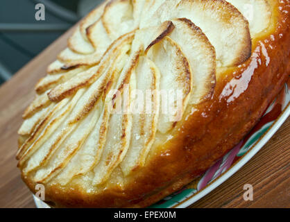 Tarte Normande - variante de la tarte aux pommes faite en Normandie rempli de pommes, amandes effilées et sucre garnie de crème anglaise oeuf crémeux Banque D'Images