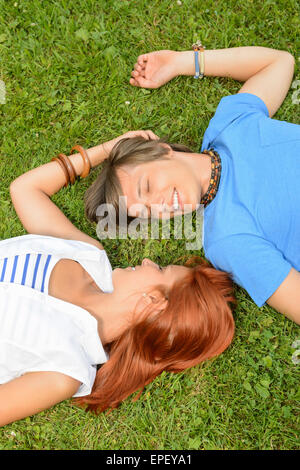 L'amour romantique jeune couple lying on grass Banque D'Images