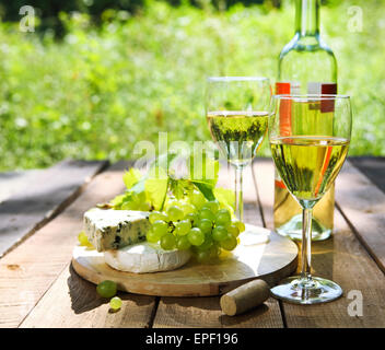 Le fromage, les raisins et deux verres de vin blanc Banque D'Images