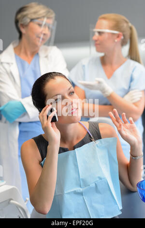 Femme occupée à l'appel patient bureau de dentiste Banque D'Images
